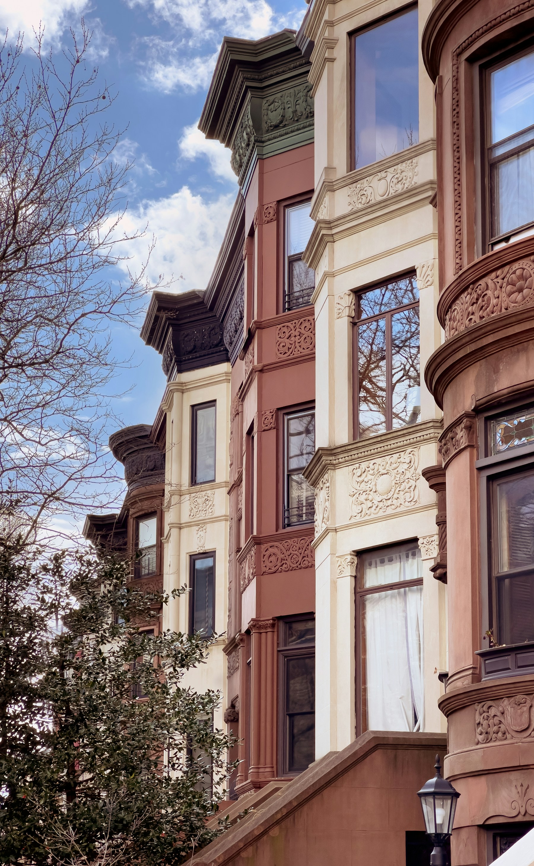 Carved stone detailing and tall windows on New York brownstone facades